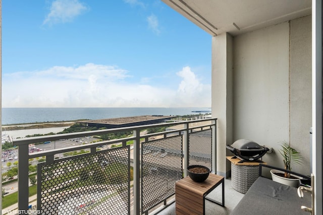 balcony featuring a view of the beach and a water view