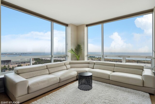 living room featuring floor to ceiling windows and a water view