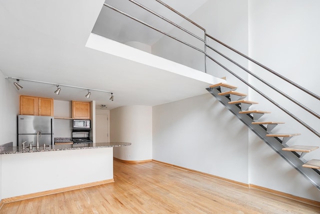 kitchen featuring stone countertops, light hardwood / wood-style floors, and appliances with stainless steel finishes