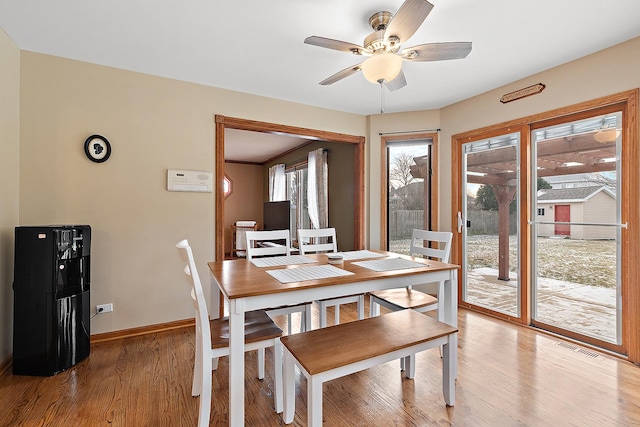 dining space with visible vents, a ceiling fan, light wood-style flooring, and baseboards