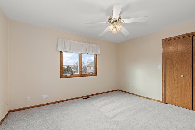 spare room with light colored carpet and ceiling fan