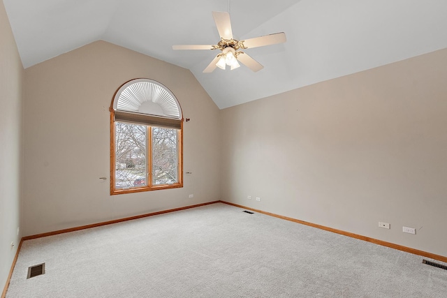 carpeted spare room featuring lofted ceiling, ceiling fan, visible vents, and baseboards