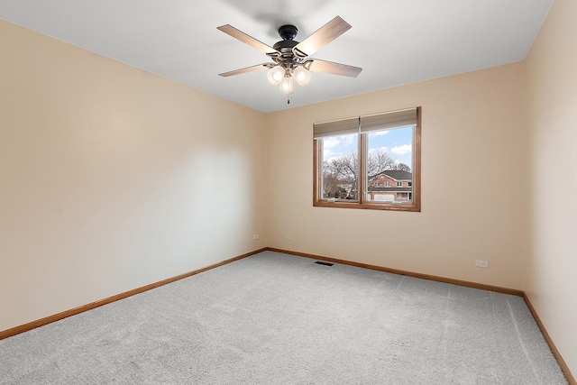 empty room featuring a ceiling fan, carpet flooring, visible vents, and baseboards