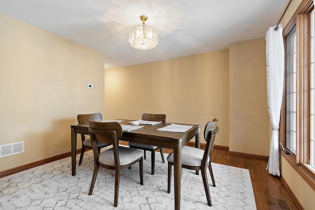 dining room with hardwood / wood-style floors and a notable chandelier