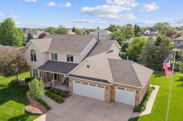 view of front of home featuring driveway, roof with shingles, an attached garage, and a front yard