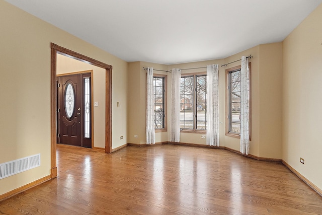 entrance foyer with wood finished floors, visible vents, and baseboards