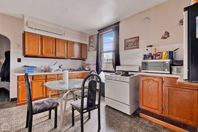 kitchen with white gas range and decorative backsplash