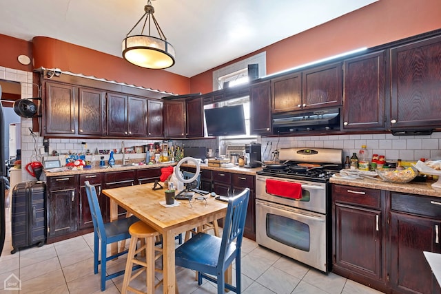 kitchen with gas stove, pendant lighting, light tile patterned floors, and exhaust hood