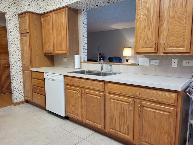 kitchen with light tile patterned flooring, white dishwasher, and sink