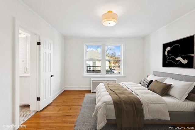 bedroom featuring crown molding, wood-type flooring, and radiator