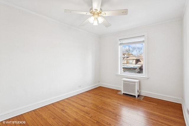 empty room with ceiling fan, ornamental molding, and hardwood / wood-style floors