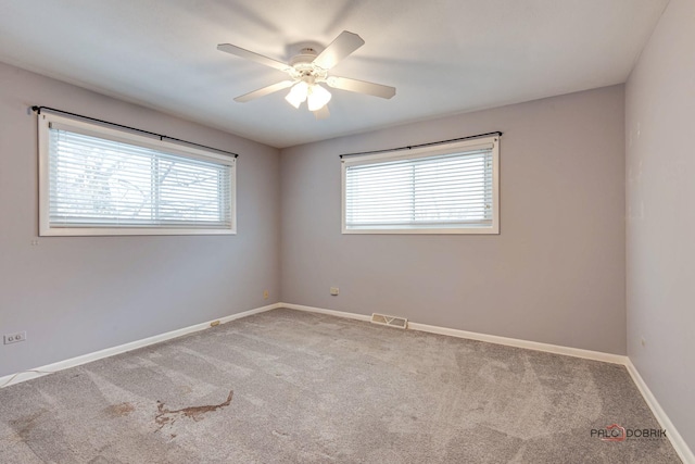 carpeted spare room with ceiling fan