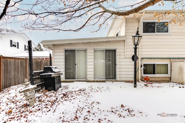 view of snow covered rear of property