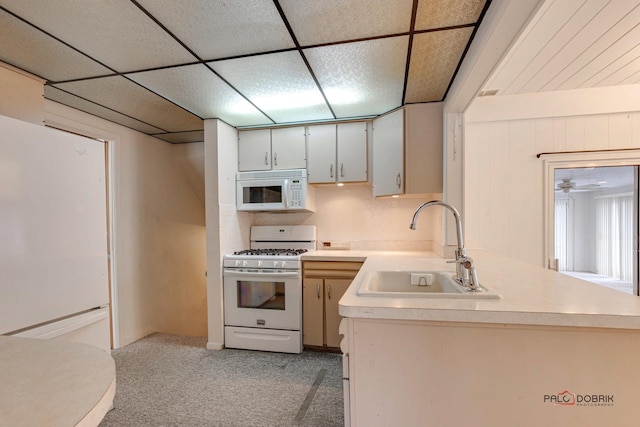 kitchen with a paneled ceiling, ceiling fan, white appliances, and sink