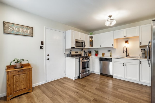 kitchen with white cabinets, light hardwood / wood-style floors, sink, and stainless steel appliances