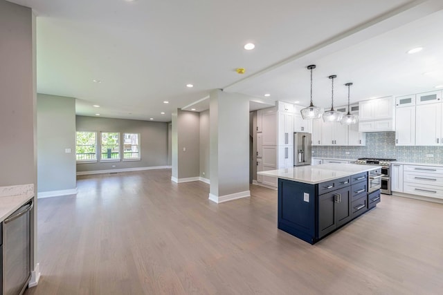 kitchen with light wood-type flooring, high end appliances, pendant lighting, white cabinets, and a kitchen island