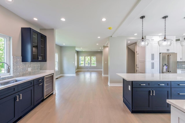 kitchen with plenty of natural light, high end fridge, sink, and tasteful backsplash