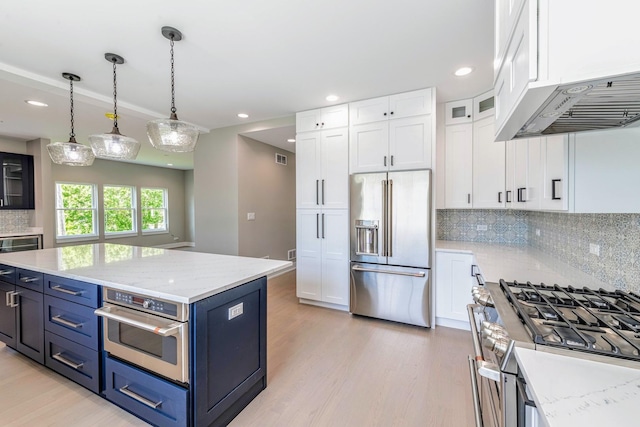 kitchen featuring tasteful backsplash, white cabinetry, hanging light fixtures, and premium appliances