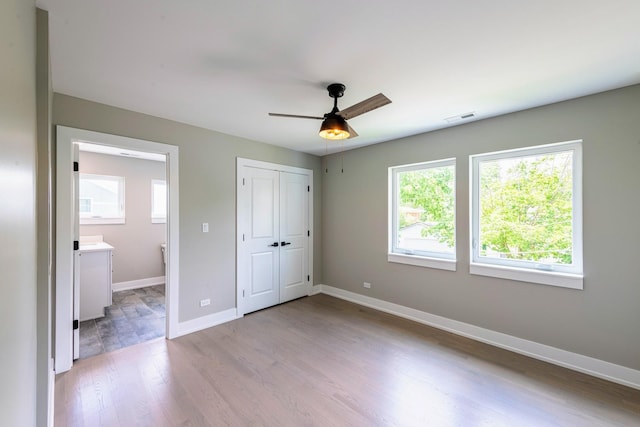 unfurnished bedroom with ceiling fan and light wood-type flooring