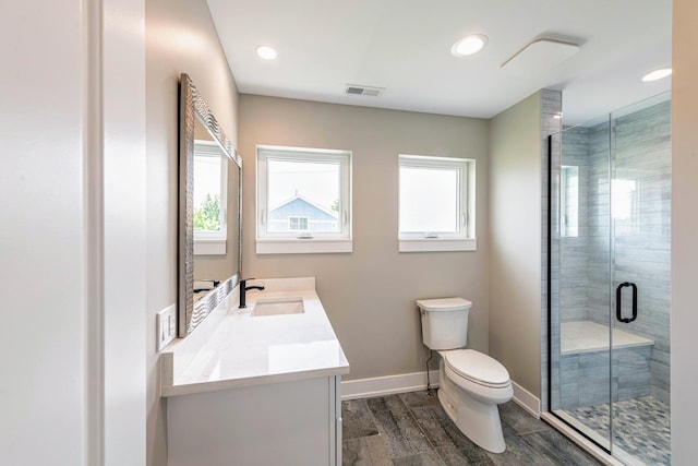 bathroom featuring vanity, toilet, a shower with door, and wood-type flooring