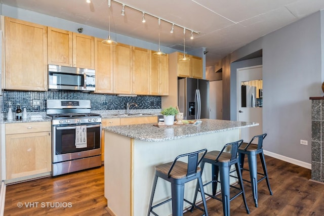 kitchen featuring stainless steel appliances, light stone countertops, sink, and light brown cabinets