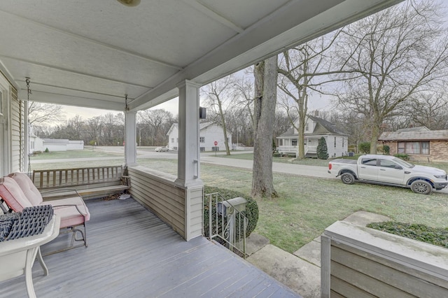 wooden deck with covered porch and a lawn