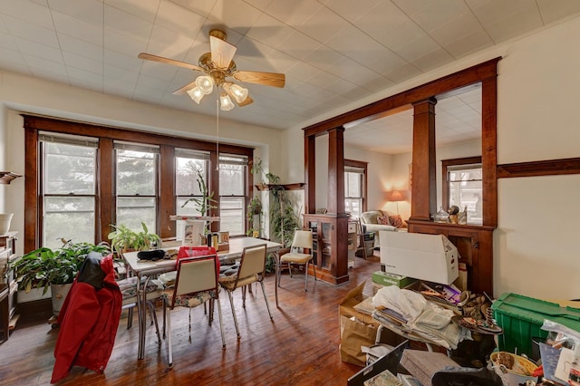 dining space with ceiling fan, dark hardwood / wood-style floors, ornate columns, and a wealth of natural light