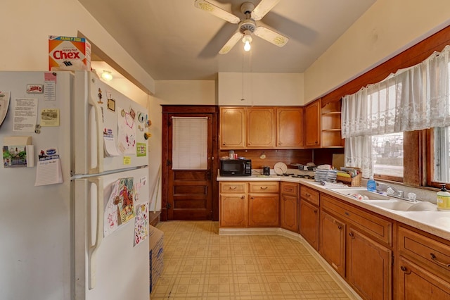 kitchen featuring ceiling fan, sink, and white fridge