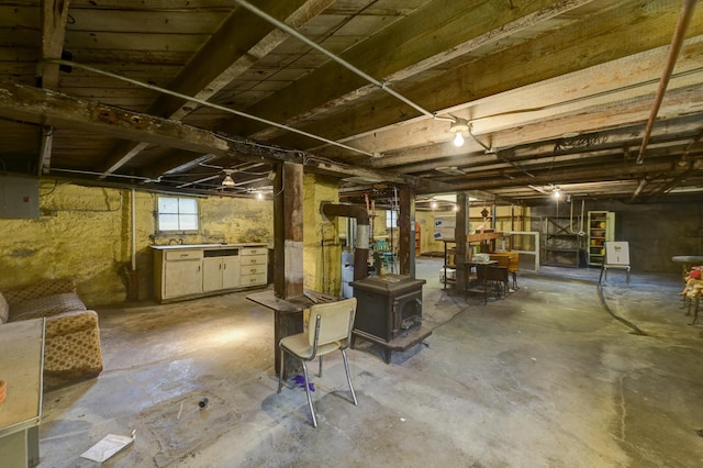 basement featuring a wood stove and electric panel