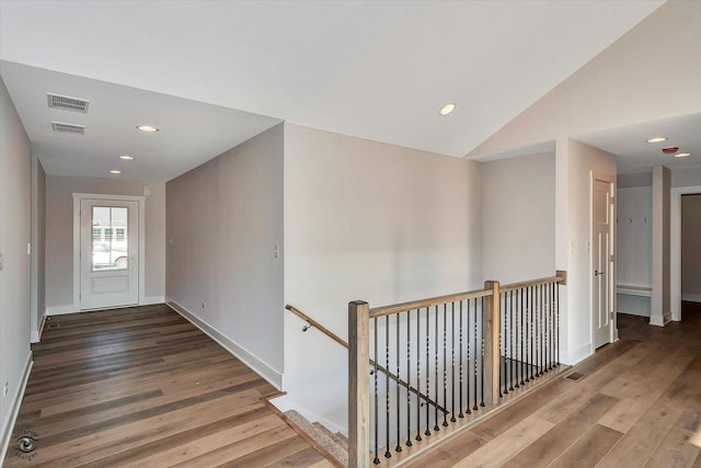 hallway with wood-type flooring and lofted ceiling