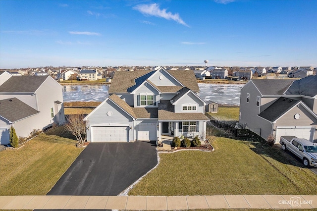 view of front of house with a front lawn and a water view