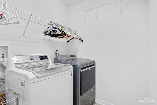 clothes washing area with separate washer and dryer