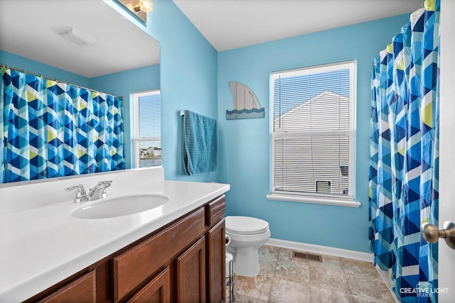 bathroom featuring vanity, a healthy amount of sunlight, and toilet