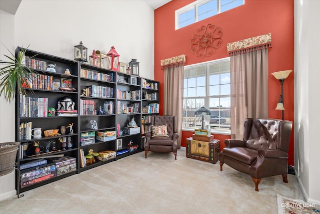 living area with light carpet and a high ceiling