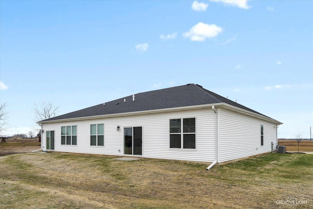 rear view of property featuring a yard and cooling unit