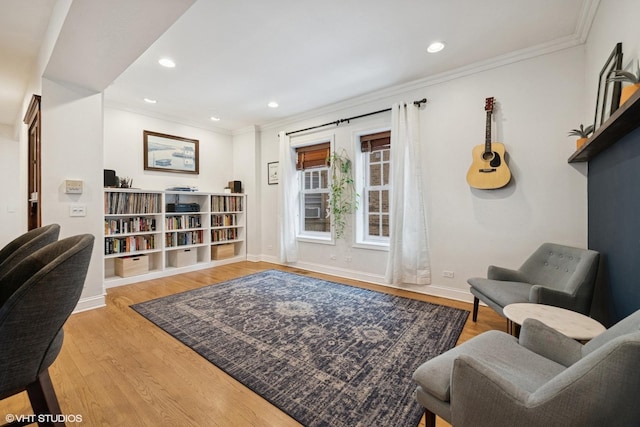 sitting room with ornamental molding, recessed lighting, wood finished floors, and baseboards