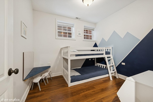 bedroom featuring visible vents, baseboards, and wood finished floors