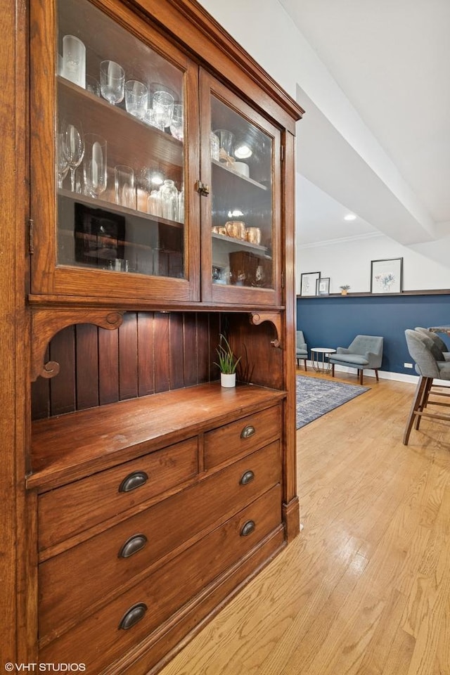 interior space with crown molding, baseboards, and wood finished floors