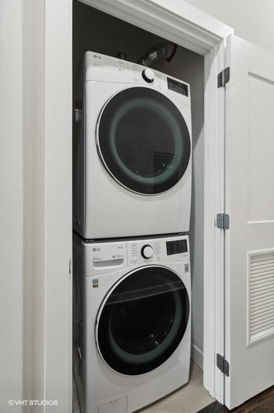 laundry room with stacked washing maching and dryer