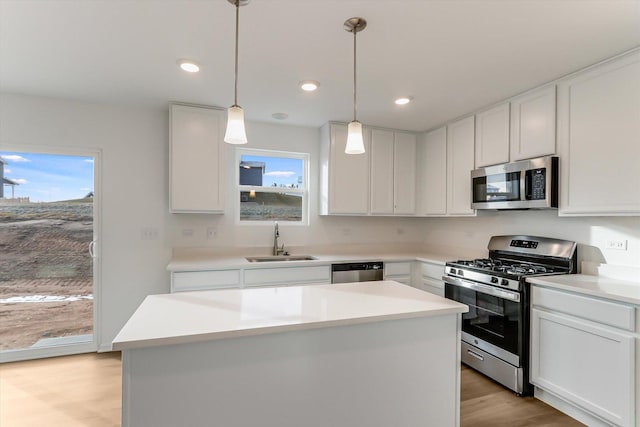 kitchen with white cabinets, a kitchen island, sink, and stainless steel appliances