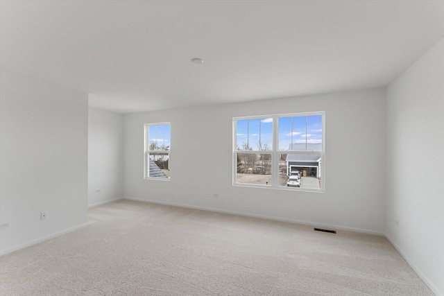 unfurnished room featuring light carpet