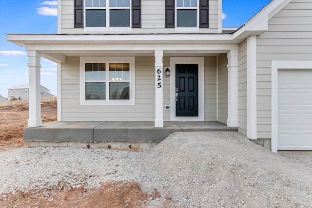 property entrance featuring a garage and covered porch