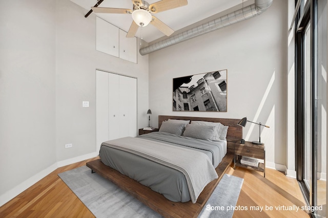 bedroom with ceiling fan, light wood-type flooring, and a closet