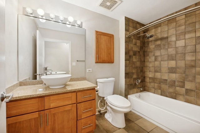 full bathroom featuring tile patterned flooring, tiled shower / bath combo, toilet, and vanity