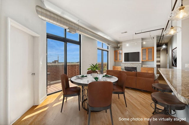 dining room featuring floor to ceiling windows and light wood-type flooring