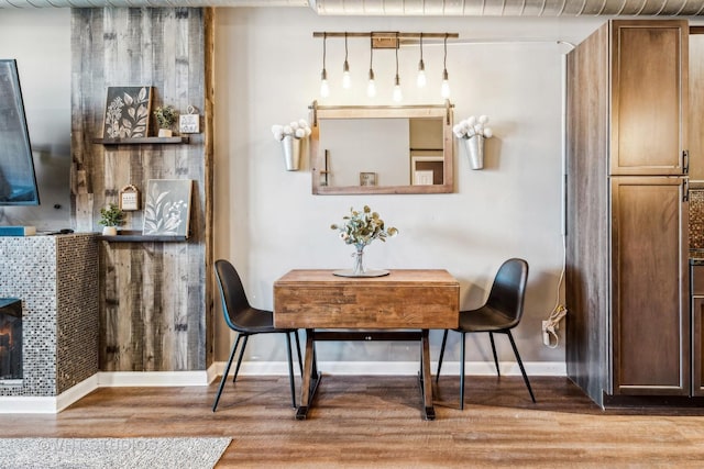 dining space with a fireplace and light hardwood / wood-style floors