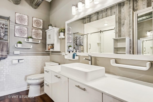 bathroom featuring hardwood / wood-style floors, vanity, tile walls, toilet, and walk in shower