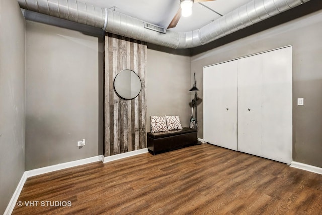 unfurnished bedroom featuring ceiling fan, wood-type flooring, and a closet