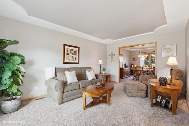 carpeted living room featuring visible vents, a tray ceiling, and baseboards