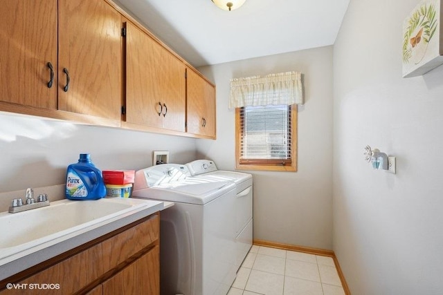 laundry room featuring washer and clothes dryer, light tile patterned floors, cabinet space, a sink, and baseboards